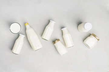 Various bottles of milk on grey concrete background