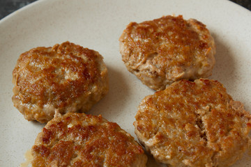 Homemade juicy minced meat patties burgers in a plate close up