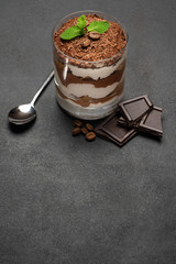 portion of Classic tiramisu dessert in a glass on concrete background