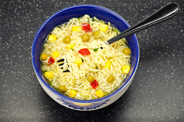 plate of noodles with vegetables on a dark background