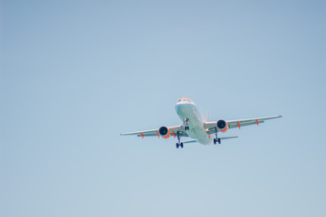 low angle view of landing aircraft on blue sky
