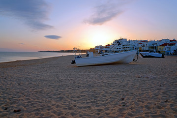 Obraz premium Traditional fisherman boat on the beach in Armacao de Pera at sunset