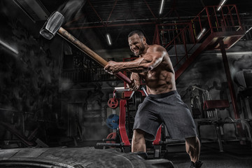 Sport Fitness Man Hitting Wheel Tire With Hammer Sledge Training, Young Healthy Guy Gym Interior - Powered by Adobe