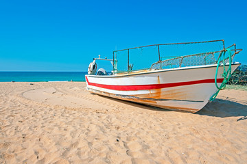 Old fishers boat on the beach in Armacao de Pera in the Algarve Portugal