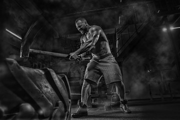 Young handsome athlete bodybuilder weightlifter doing crossfit workout workout, in a modern gym, strong back muscles. With a bare torso. Idialnye muscles. Concept - strength