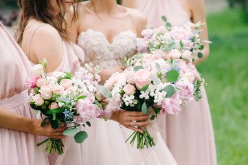 Bridesmaid's bouquets, wedding bouquets close up. Stylish wedding. Contemporary fashion wedding trends. Elegant beautiful style. Modern wedding concept. Bridesmaids holding wedding bouquets outdoor. 