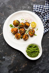 Tandoori aloo are roasted potatoes with Indian spices. It's a party appetiser served with green chutney. selective focus