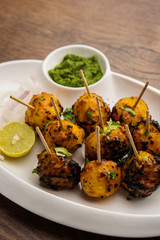 Tandoori aloo are roasted potatoes with Indian spices. It's a party appetiser served with green chutney. selective focus