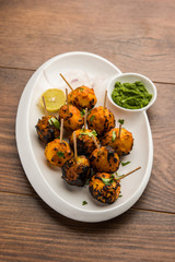 Tandoori aloo are roasted potatoes with Indian spices. It's a party appetiser served with green chutney. selective focus