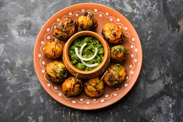 Obraz na płótnie Canvas Tandoori aloo are roasted potatoes with Indian spices. It's a party appetiser served with green chutney. selective focus