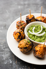 Tandoori aloo are roasted potatoes with Indian spices. It's a party appetiser served with green chutney. selective focus