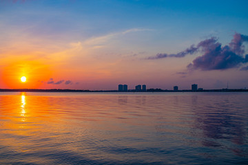Naklejka premium Beautiful sun over the city of Fort Myers skyline reflecting of the gulf of Mexico 