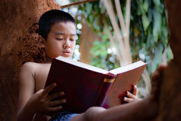 Asian boys are reading books in the clay house.