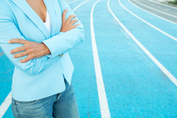 Close up portrait of business woman while standing with arms crossed on a athletics court