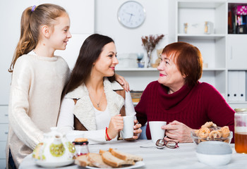 Obraz na płótnie Canvas Senior woman with family drinking tea at home