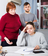 Frustrated woman with papers and discontented family