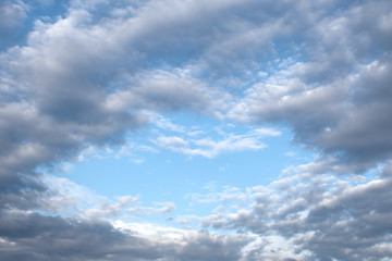 View of the sky blue in the form of a heart through the air clouds of gray