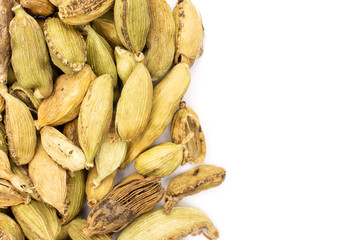 Lot of whole true cardamom pod on the left side with copyspace flatlay isolated on white background