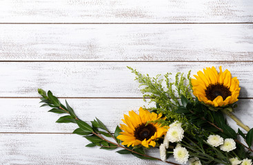 A Yellow sunflower arrangement on white wood background with copy space