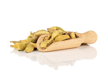 Lot of whole true cardamom pod with wooden scoop isolated on white background