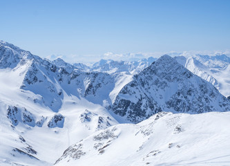 View on winter landscape from the top of Schaufelspitze mountain at Stubai Gletscher ski area with snow covered peaks at spring sunny day. Blue sky background. Stubaital, Tyrol, Austrian Alps