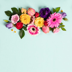 Creative layout made with beautiful flowers on blue background.