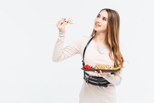 Gorgeous long haired model eating chinese food against white background in a studio environmen. Copy space!