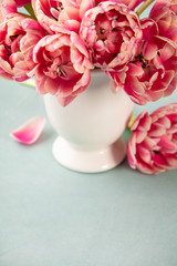 Bouquet of Spring tulips in vase on shabby chic background