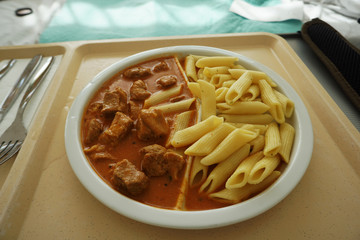 Goulash with sauce and noodles served for dinner on the tray