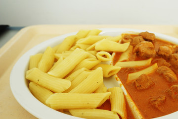 Goulash with sauce and noodles served for dinner on the tray