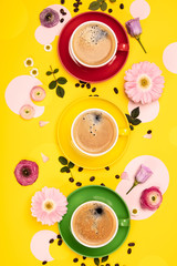 Cups of Coffee and colorful paper circles on yellow paper backgr