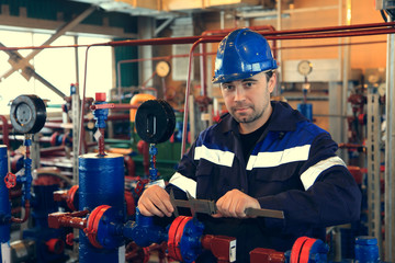 The mechanic - the repairman tightens bolts on a flanged connection of pipeline armature