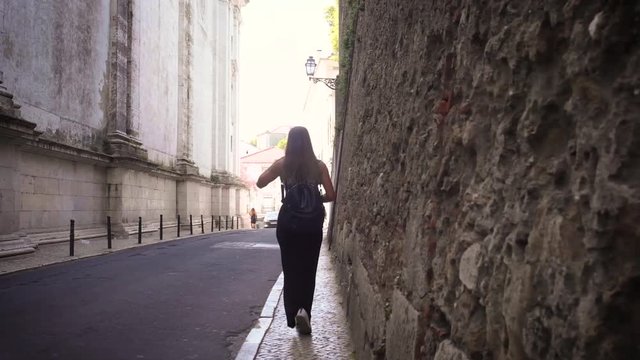woman walking near an old wall