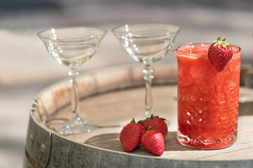 Summer Slushy made from strawberries, smoothies, ice with some ingredients nearby over wooden background