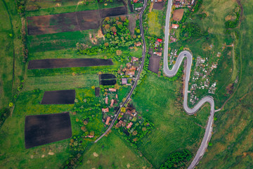Curvy road from a drone view and agriculture fields