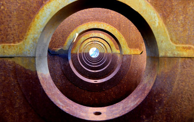 A tunnel or series of symmetrical circular holes with progressively smaller patterns to the distant horizon