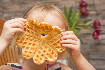 The child eats Belgian waffles.