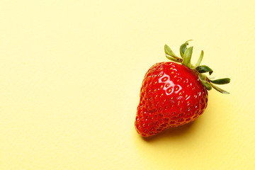 ripe juicy strawberries on a yellow background with space for text