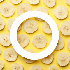 Creative summer pattern made of bananas slice on pastel yellow background. with frame . Fruit minimal concept. Flat lay.