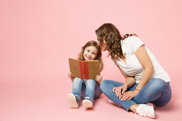 Woman in light clothes have fun read book with child baby girl. Mother, little kid daughter...