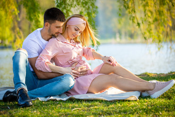 Fototapeta premium Happy couple expecting baby, pregnant woman with husband, young family and new life concept