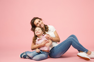 Obraz na płótnie Canvas Woman in light clothes have fun with cute child baby girl. Mother, little kid daughter isolated on pastel pink wall background, studio portrait. Mother's Day, love family, parenthood childhood concept