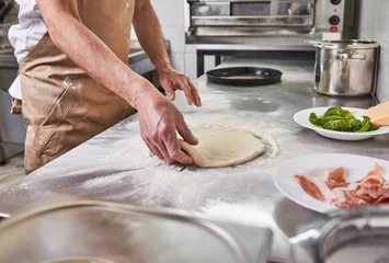 Foto auf Acrylglas Processing of the pizza dough by the pizza maker at Italian restaurant kitchen  © Karanov images