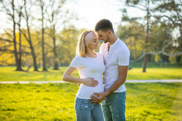 Happy couple expecting baby, pregnant woman with husband, young family and new life concept