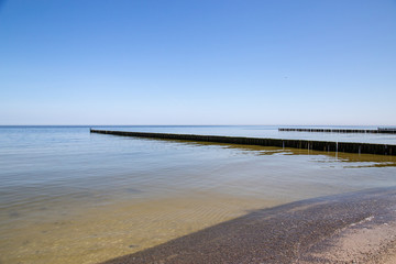 Groynes in the Baltic Sea with small waves in the seaside resort of Zempin on the island of Usedom