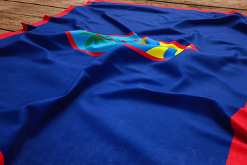 Flag of Guam on a wooden desk background. Silk flag top view.