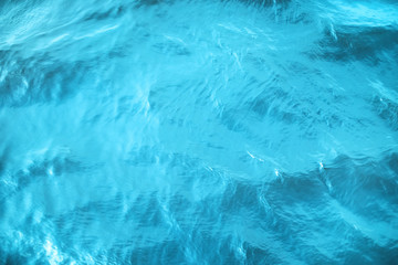 Closeup of calm river water surface with water splashes in blue color. Ideal river, sea and ocean texture. Trendy fresh abstract nature background.
