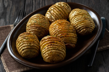 Hasselback potatoes baked with garlic and herbs in oven.