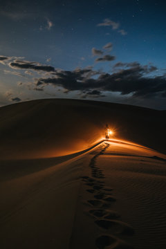 lost woman with lantern walking through the desert at night