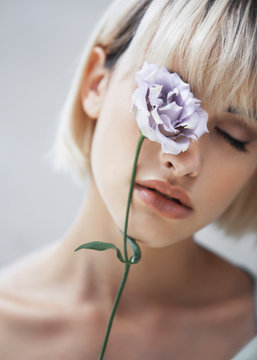 woman with a lilac flower over her eye